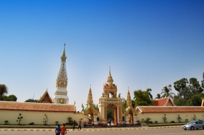The white and gold Phra That Phanom behind the temple wall, Nakhon Phanom