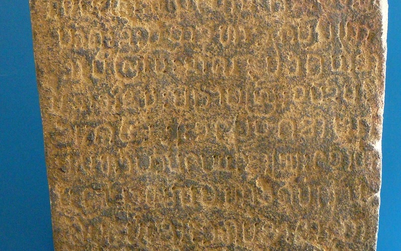 The Wat Lam Chang stone inscription of 1444, its face covered with carved letters, on display at the Hariphunchai National Museum, Lamphun