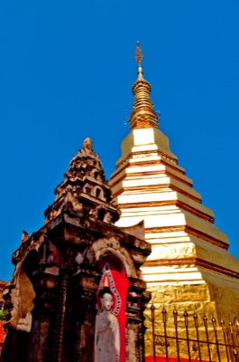 The golden chedi of Phra That Cho Hae, Phrae, under a blue sky