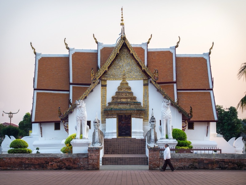 The vihara of Wat Phumin in Nan, a white cross-shaped hall with tiered red roofs and naga stairs in front
