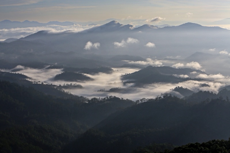 A white sea of morning mist drifting over layer upon layer of mountain ridges in Mae Surin Waterfall National Park, Mae Hong Son