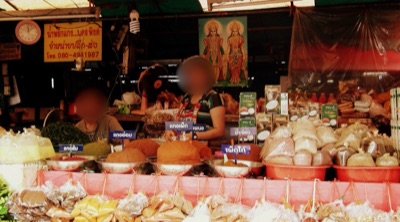แผงขายของแห้งในตลาดเชียงใหม่ มีถาดขนมและถุงของวางเรียงเต็มหน้าแผง