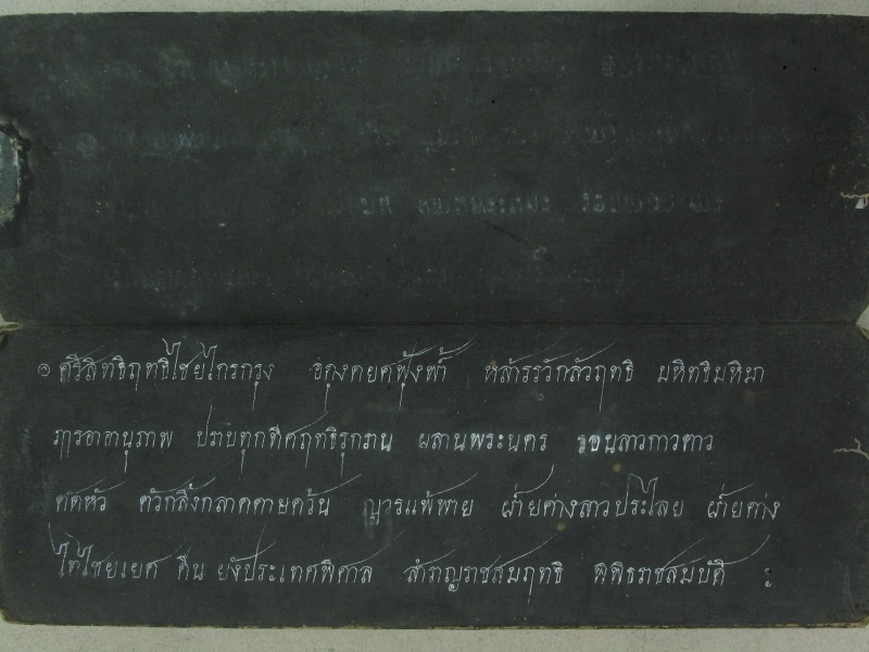 A black folding-book page in two panels; the lower panel is written in white ink and begins Si sit rit chai krai krung