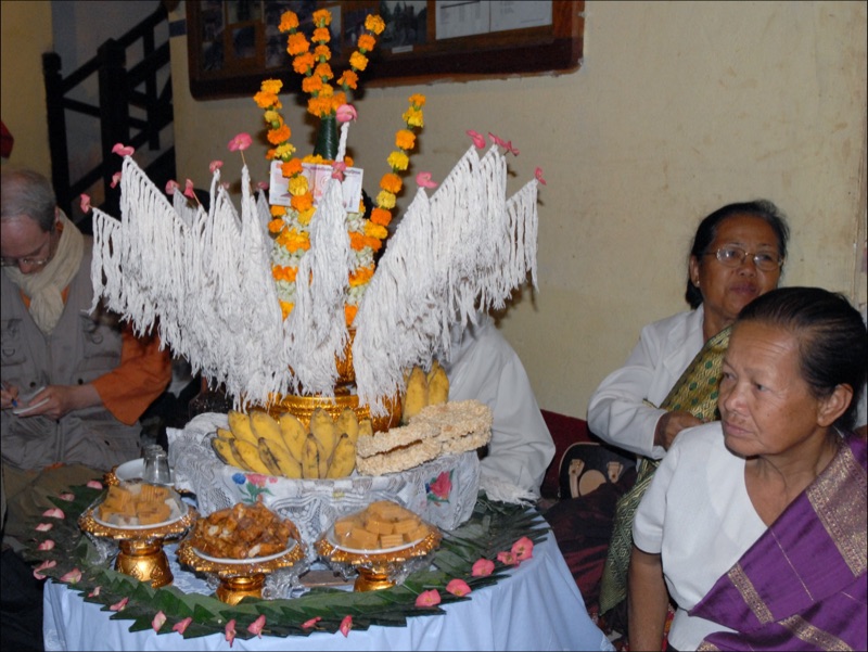 ขันบายศรีประดับดอกดาวเรือง ฝ้ายขาว กล้วย และขนม วางกลางวงผู้ร่วมพิธีสู่ขวัญที่หลวงพระบาง