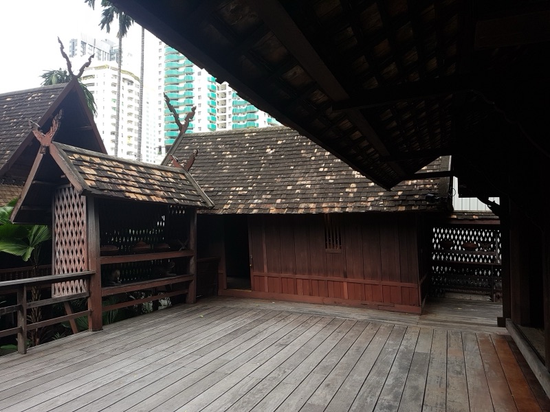 ชานไม้ของเรือนคำเที่ยง หลังคามุงแป้นเกล็ด มีกาแลไม้แกะสลักไขว้กันบนยอดจั่วหลายหลัง