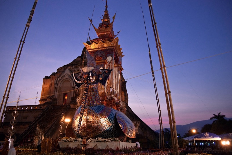 A funeral pyre shaped like the hatsadiling bird, with an elephant head, standing before Wat Chedi Luang in Chiang Mai at dusk