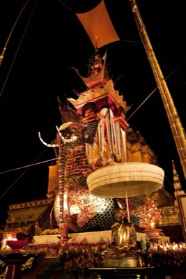 ปราสาทศพบนหลังนกหัสดีลิงค์ยามค่ำ หัวช้างมีงา บนหลังเป็นเรือนยอดสีทองซ้อนชั้น