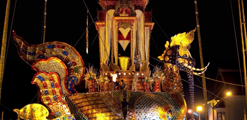 ปราสาทศพทรงนกหัสดีลิงค์ หัวเป็นช้าง มีงวงและงา บนหลังมีเรือนยอดสีทอง ตั้งที่วัดเจดีย์หลวง เชียงใหม่ ยามค่ำ ช่างกำลังตกแต่งอยู่ไกล ๆ