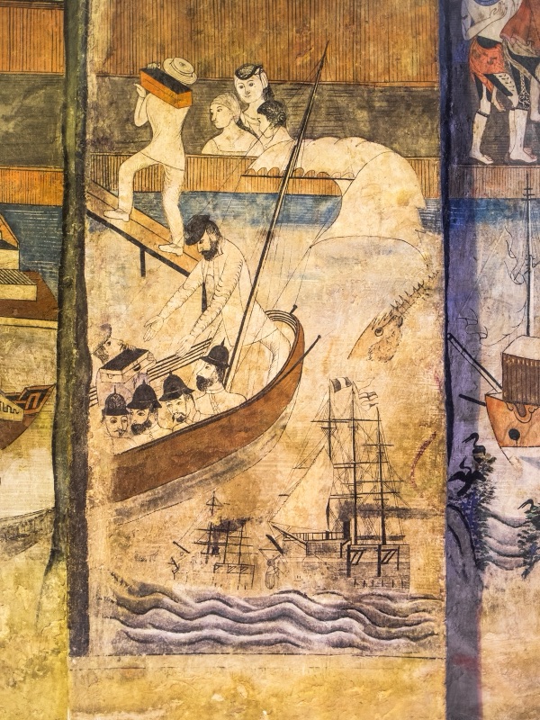 A faded mural of a steamship with a funnel and masts on painted waves, with a large wooden boat and small figures above it