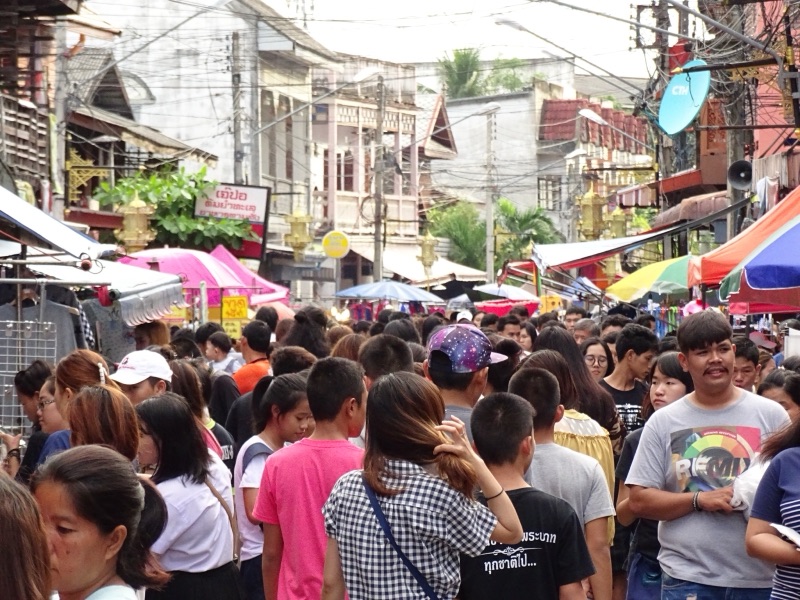 Crowds walking through the Kad Kong Ta walking street on Talat Kao Road in Lampang, lined with shops and old buildings