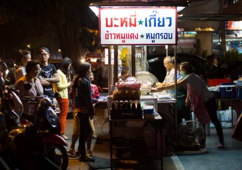 People queuing for food at a roadside stall on Manee Nopparat Road, Chiang Mai, at night