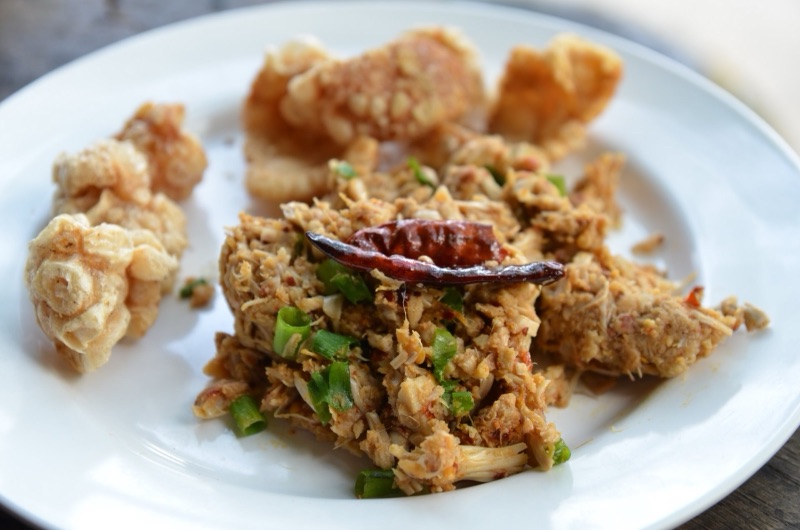Northern Thai jackfruit salad: young jackfruit pounded with chilli paste, topped with spring onions and a fried dried chilli, with pork cracklings beside it