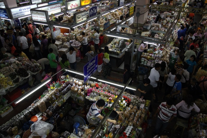 ภายในกาดวโรรส เชียงใหม่ มองจากชั้นบน เห็นแผงขายของแห้งและผู้คนเดินจับจ่ายแน่นตลาด