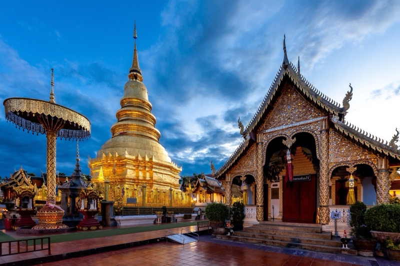 พระบรมธาตุหริภุญชัยสีทองและวิหารล้านนาประดับลายคำ วัดพระธาตุหริภุญชัยวรมหาวิหาร ลำพูน ยามพลบค่ำ