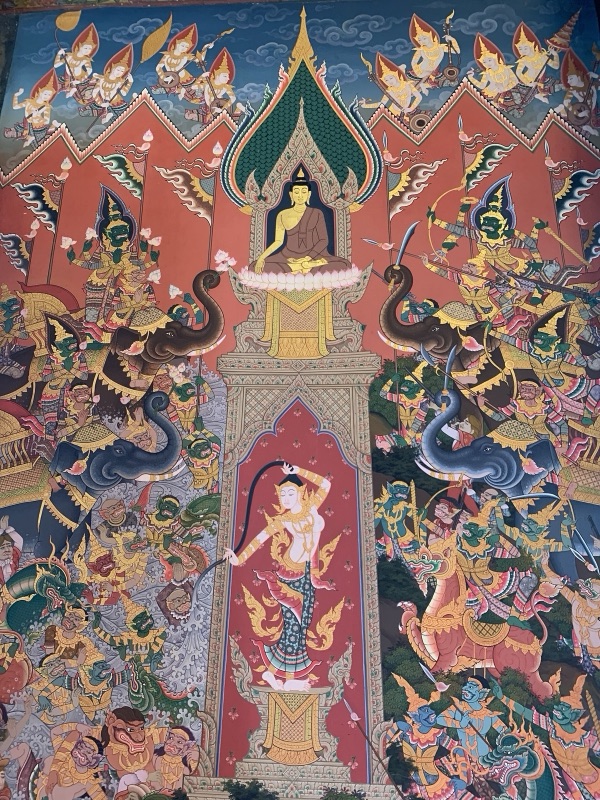 จิตรกรรมฝาผนังพระแม่ธรณีบีบมวยผมอยู่กลางภาพ เหนือขึ้นไปคือพระพุทธรูปนั่งใต้ซุ้ม สองข้างเป็นกองทัพมารบนช้างและสัตว์ต่าง ๆ