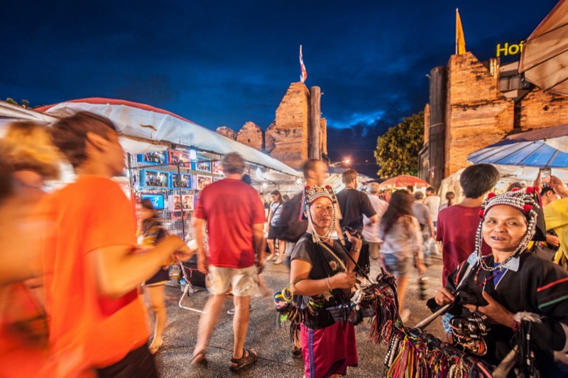 People strolling along the Tha Phae walking street in Chiang Mai in the evening, past stalls and food shops