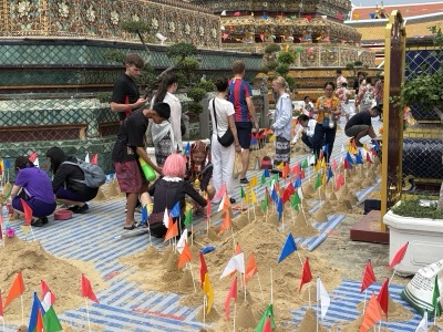 เจดีย์ทรายหลายองค์ปักธงสีสันในลานวัดช่วงสงกรานต์