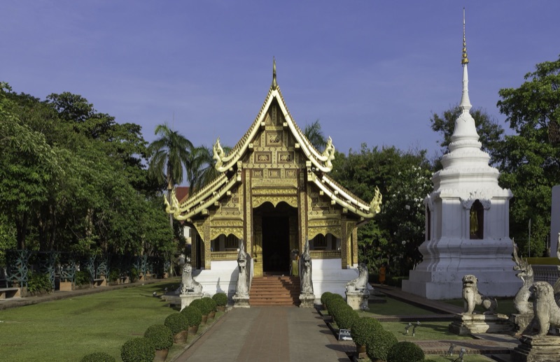 อาคารหน้าบันปิดทองแบบล้านนาในวัดพระสิงห์ เชียงใหม่ มีนาคและสิงห์เฝ้าบันได และเจดีย์สีขาวอยู่ทางขวา