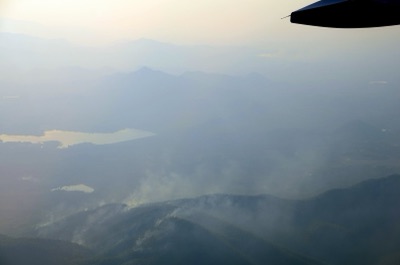 A grey curtain of smoke over several mountain ridges