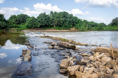 A rock weir across the Ping River with water flowing over the stones
