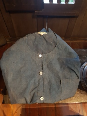 A dark-blue round-necked mo hom shirt with buttons and a pocket
